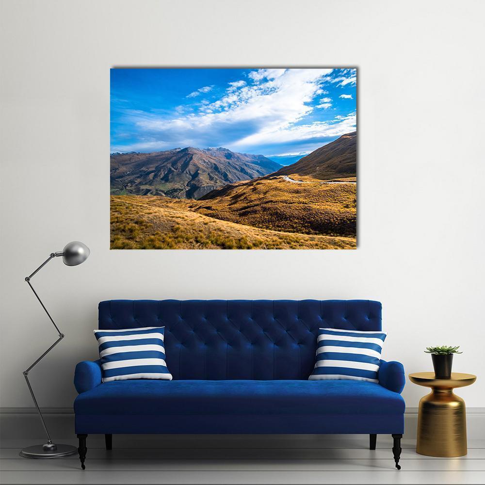 Crown Range Road Between Queenstown and Wanaka Canvas Wall Art in brown, yellow and blue, single panel hung on a wall