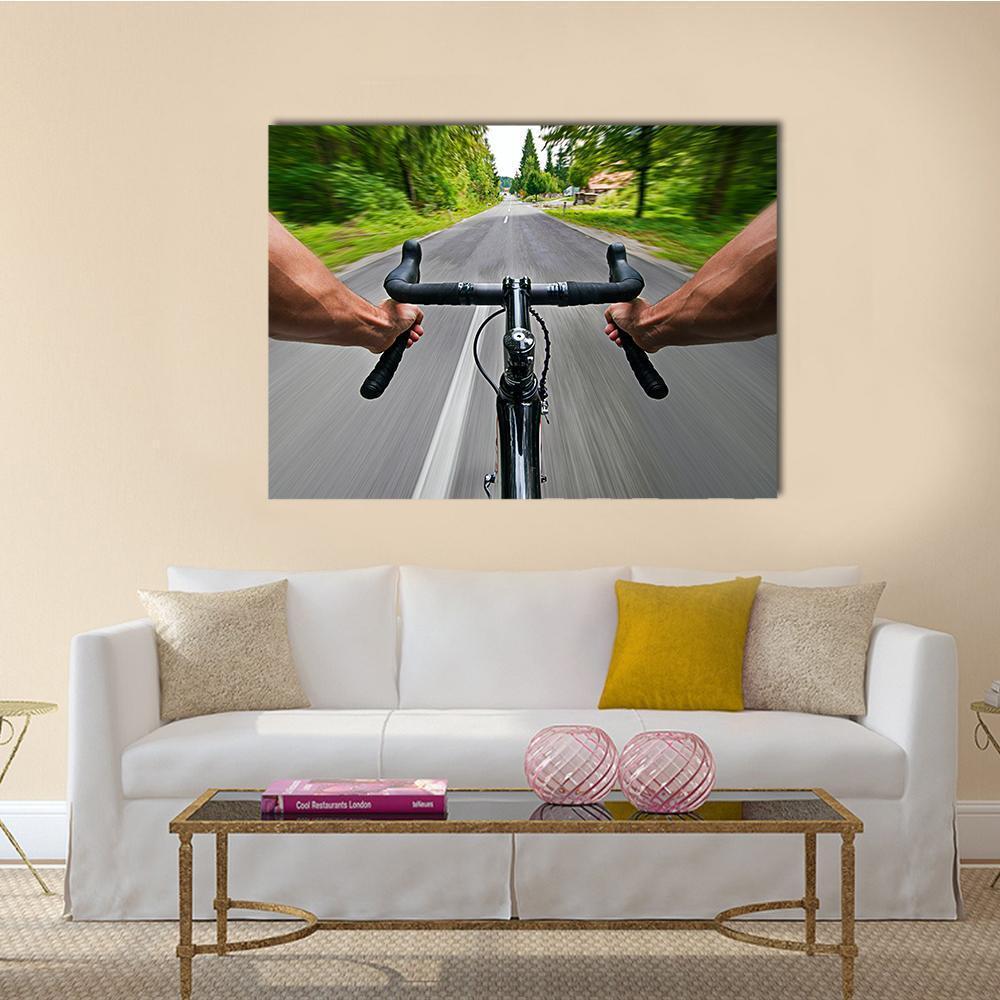 First Person Road Cycling View Canvas Wall Art in black, gray and green, single panel hung on a wall