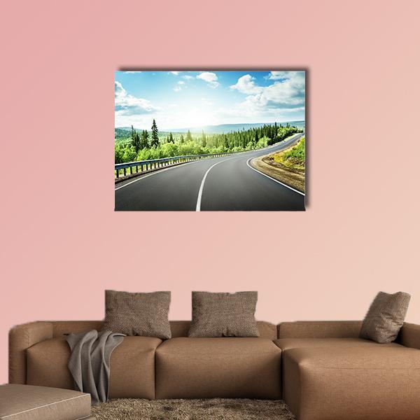 Winding Mountain Road Through Forest Canvas Wall Art in gray, green and blue, single panel hung on a wall