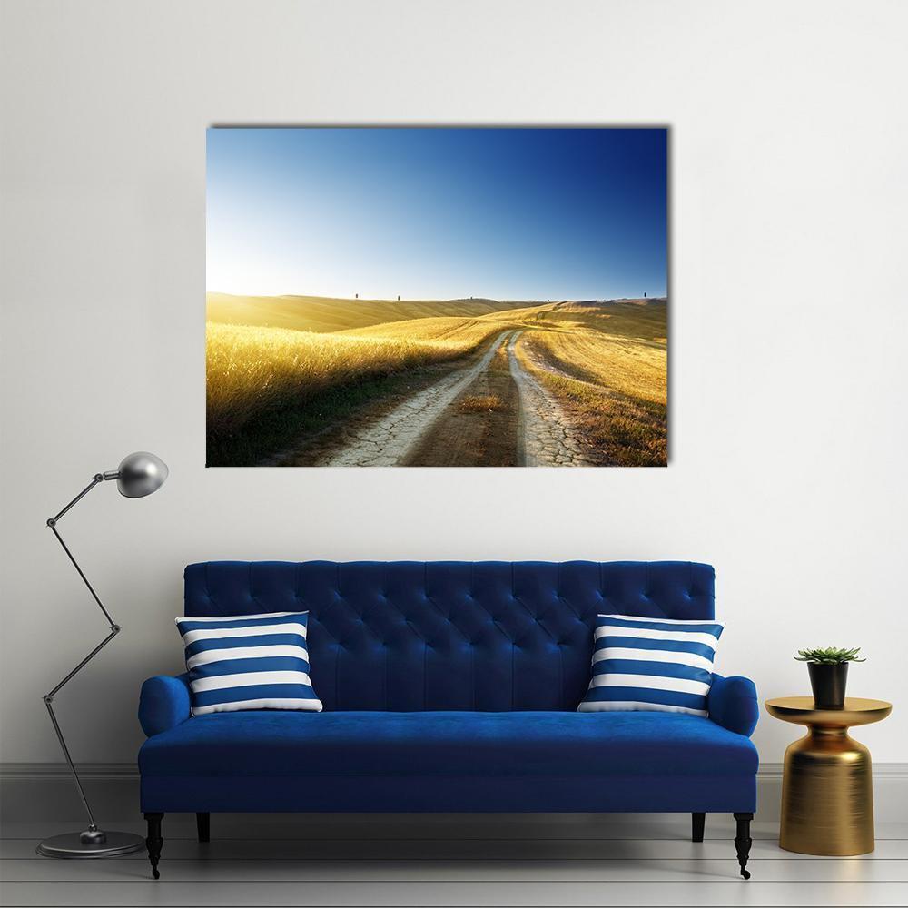Tuscan Road at Sunset Canvas Wall Art in brown, yellow and blue, single panel hung on a wall