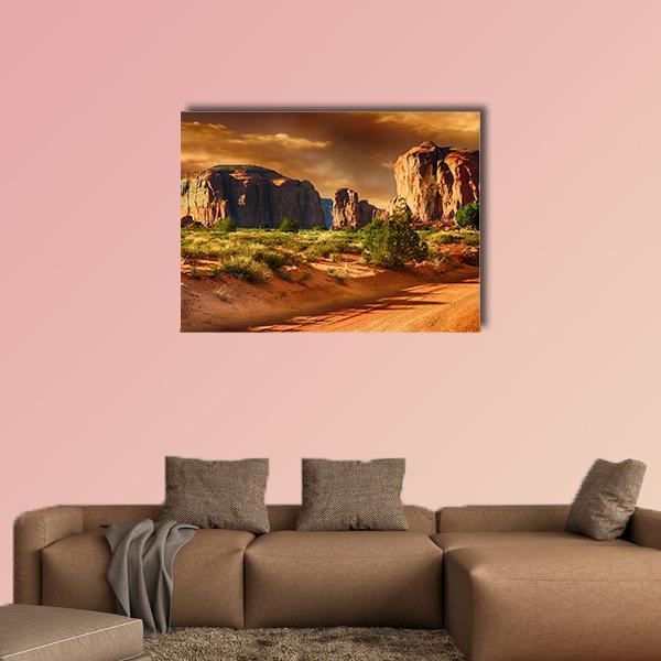 Monument Valley Road at Golden Hour Canvas Wall Art in brown, gold and orange, single panel hung on a wall