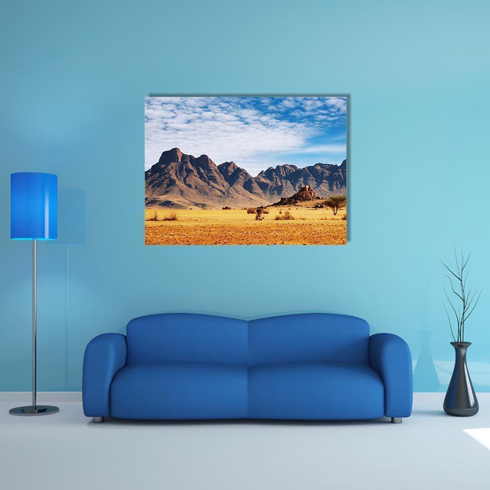 Rocks of Namib Desert Canvas Wall Art in brown, yellow and blue, single panel hung on a wall