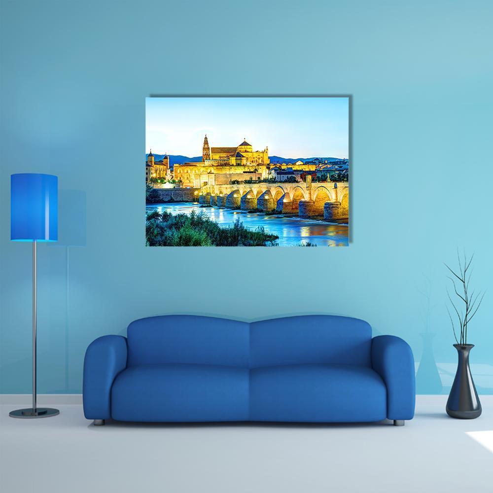 Roman Bridge Over Guadalquivir River at Dusk Canvas Wall Art in gold, yellow and blue, single panel hung on a wall