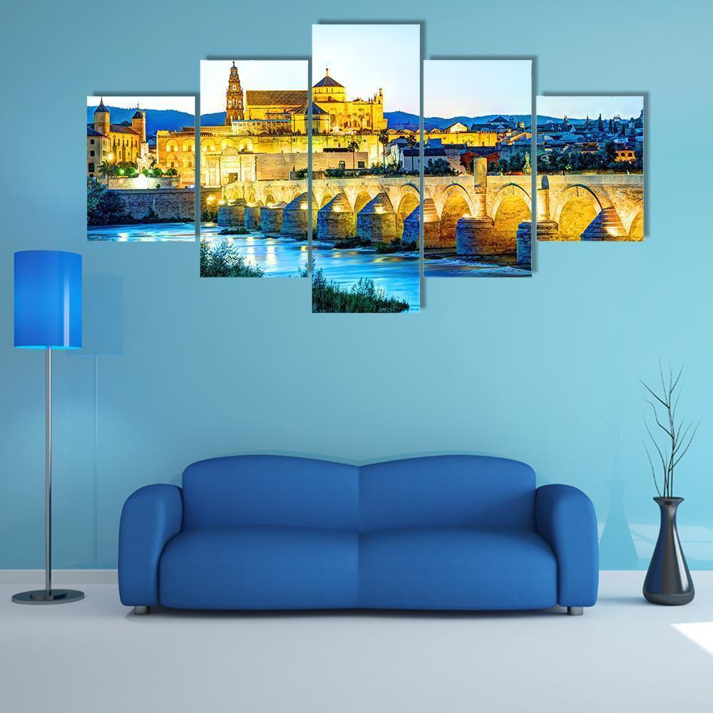 Roman Bridge Over Guadalquivir River at Dusk Canvas Wall Art in gold, yellow and blue, 5 panel Star layout hung on a wall