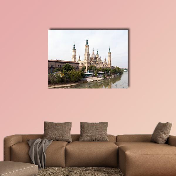Roman Catholic Basilica by the River, Spain Canvas Wall Art in white, beige and brown, single panel hung on a wall