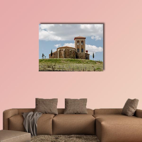 Romanesque Hermitage on a Hill Canvas Wall Art in brown, green and blue, single panel hung on a wall