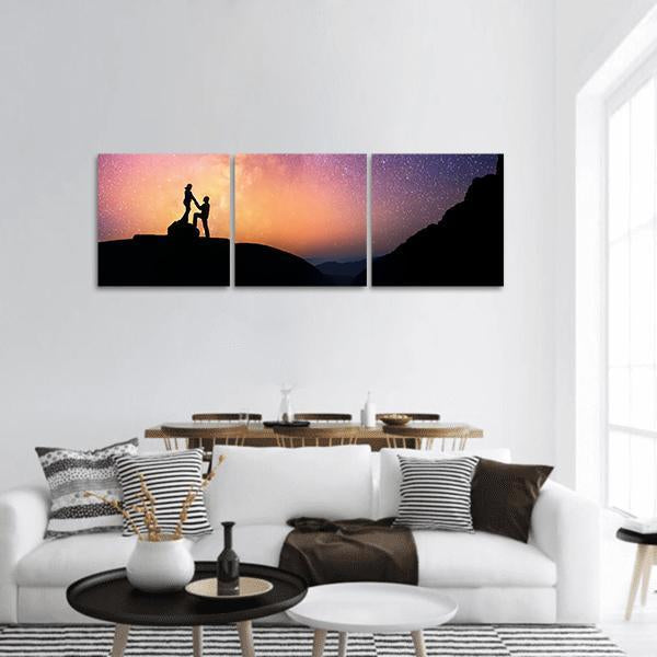 Mountain Proposal Under the Milky Way Panoramic Canvas Wall Art in black, orange and purple, hung on a wall
