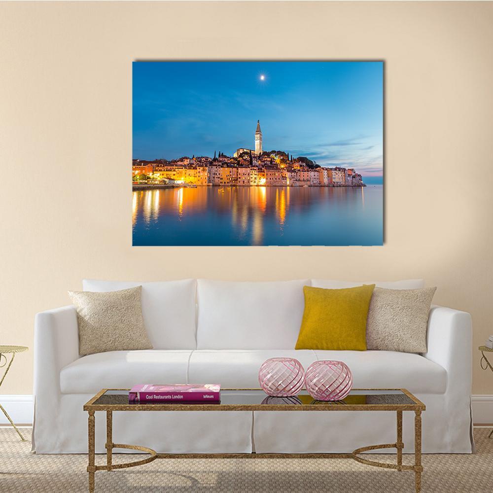 Rovinj Dusk Skyline with Church Tower Canvas Wall Art in orange, yellow and blue, single panel hung on a wall