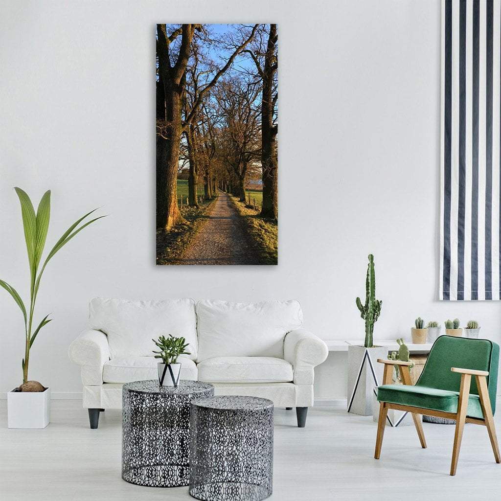 Trees Lining a Winter Path Vertical Canvas Wall Art in black, brown and blue, single vertical panel hung on a wall