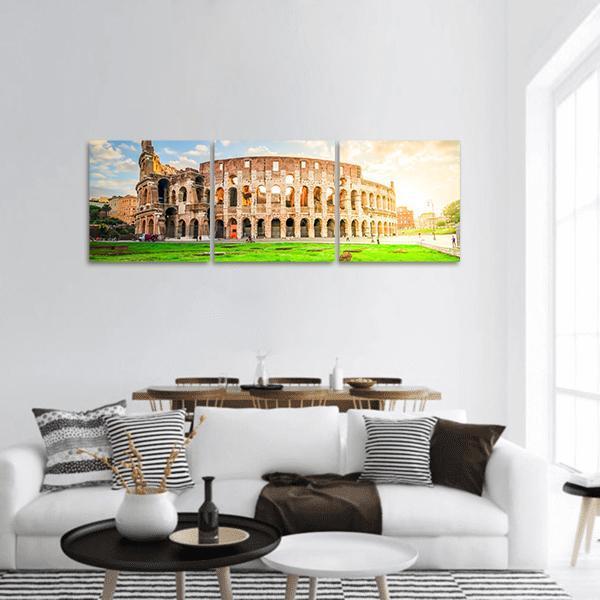 Ruins of the Colosseum in Rome Panoramic Canvas Wall Art in beige, green and blue, hung on a wall