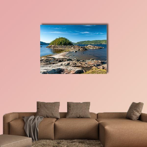 Rocky Shoreline and Lush Island Canvas Wall Art in brown, green and blue, single panel hung on a wall