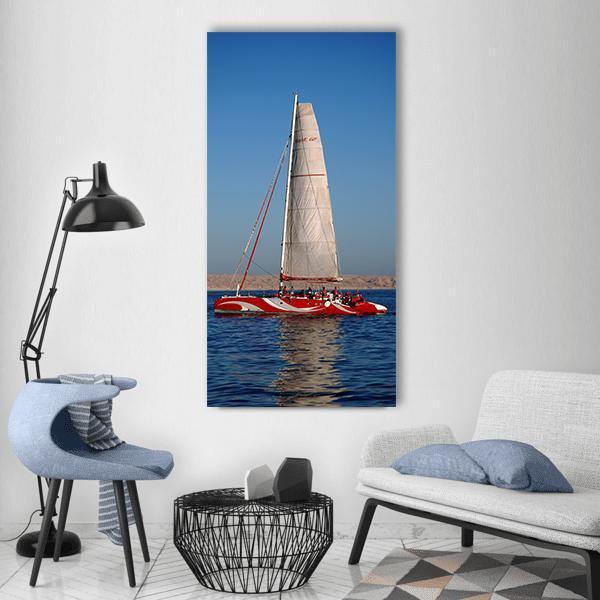 Red-striped Catamaran on Deep Blue Sea Vertical Canvas Wall Art in white, red and blue, single vertical panel hung on a wall