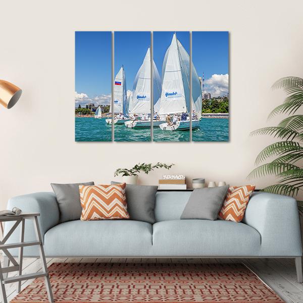 Three Sailboats in a Regatta Canvas Wall Art in white and blue, hung on a wall