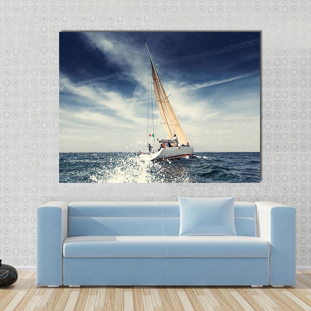 Sailboat Cutting Through Ocean Spray Canvas Wall Art in white, blue and navy, single panel hung on a wall