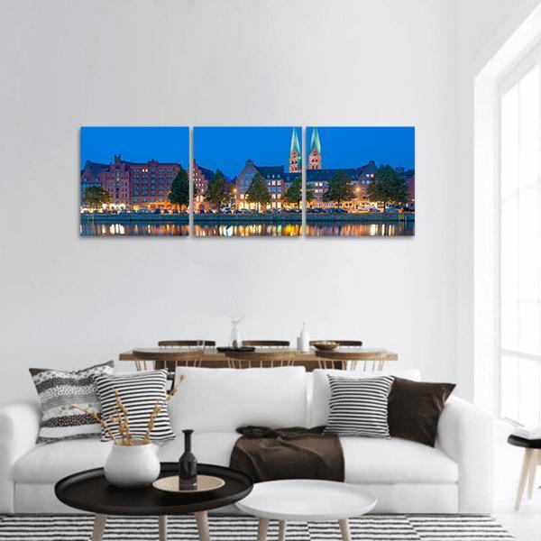 River Untertrave Church Reflections Panoramic Canvas Wall Art in brown, yellow and blue, hung on a wall