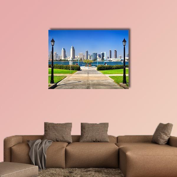 Park Path to City Skyline Canvas Wall Art in gray, green and blue, single panel hung on a wall