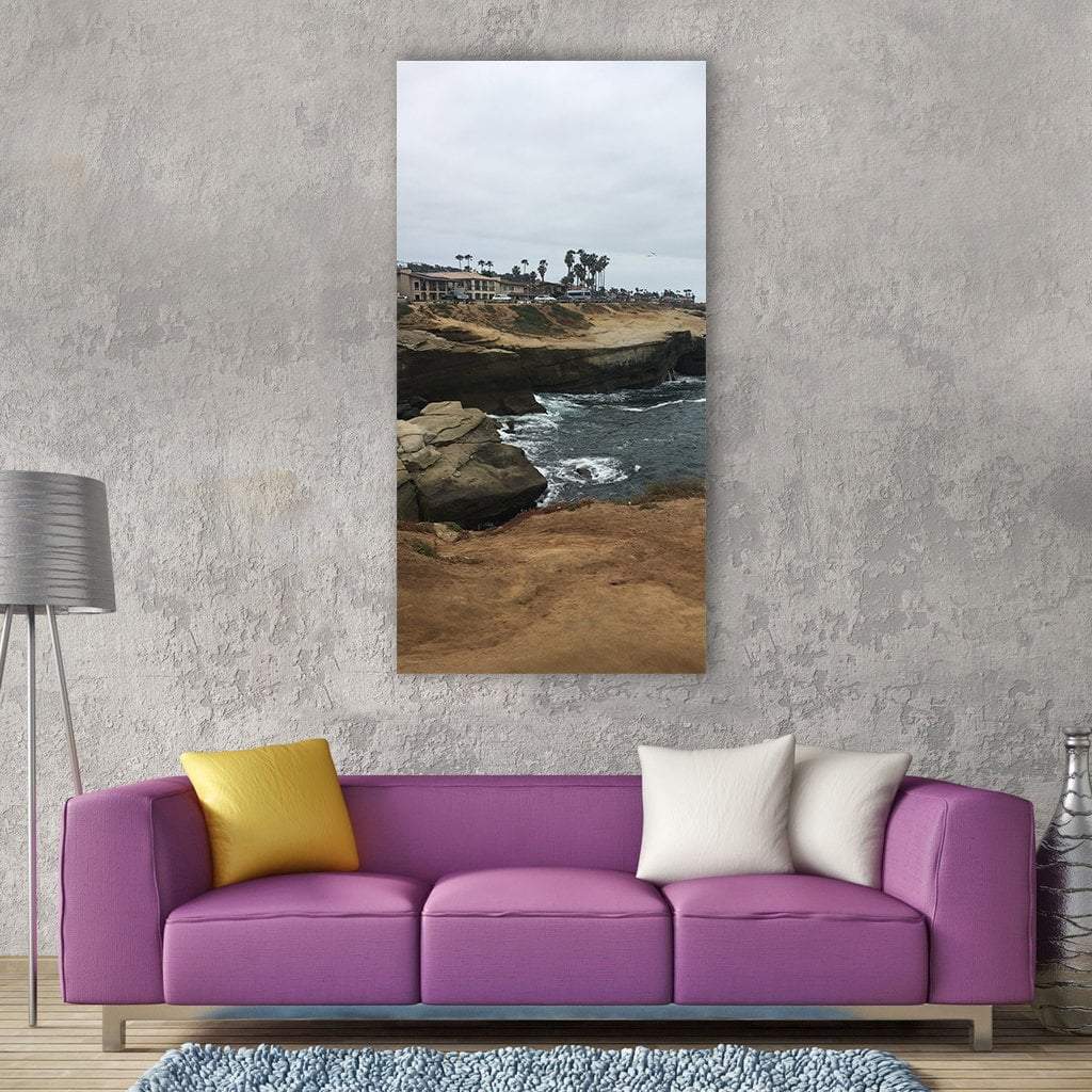San Diego Coastal Cliffs with Palm Trees Vertical Canvas Wall Art in gray, brown and blue, single vertical panel hung on a wall