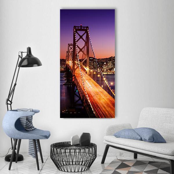 San Francisco Bay Bridge Skyline at Dusk Vertical Canvas Wall Art in black, orange and purple, single vertical panel hung on a wall