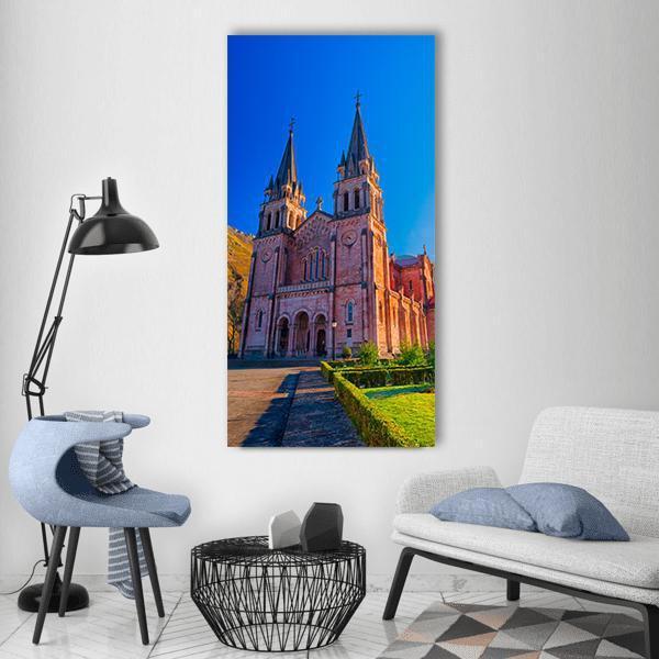 Sanctuary of Covadonga Cathedral Vertical Canvas Wall Art in brown, green and blue, single vertical panel hung on a wall
