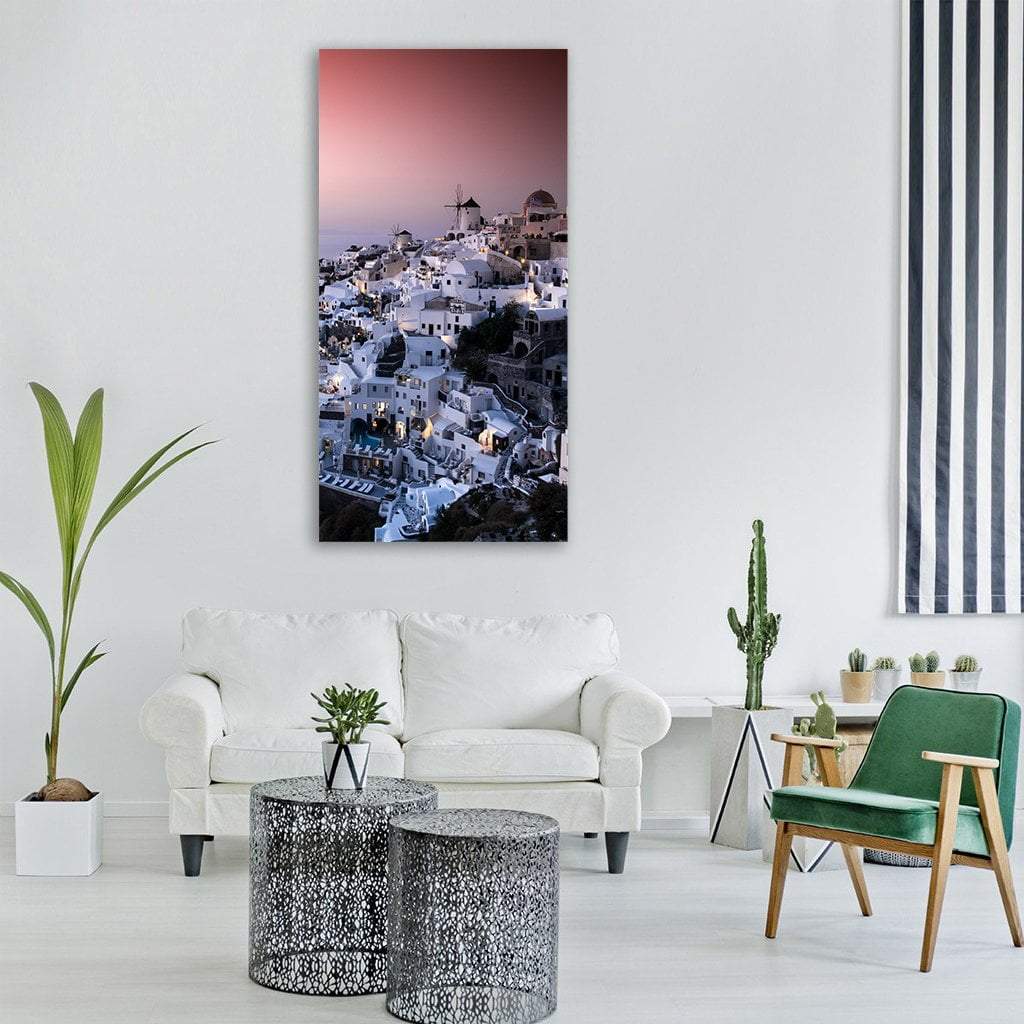 Oia Santorini at Dusk Vertical Canvas Wall Art in white, blue and pink, single vertical panel hung on a wall
