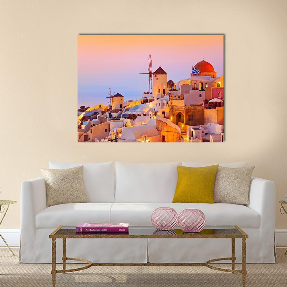 Santorini Sunset Over Oia Village Canvas Wall Art in white, orange and pink, single panel hung on a wall