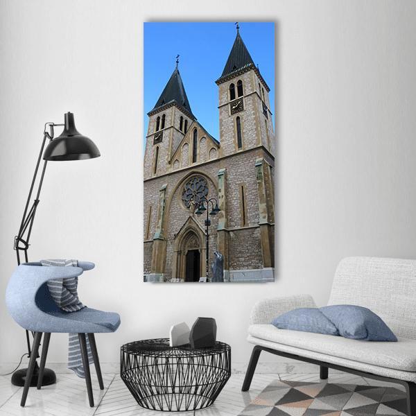 Sarajevo Cathedral Facade with Twin Towers Vertical Canvas Wall Art in gray, beige and blue, single vertical panel hung on a wall