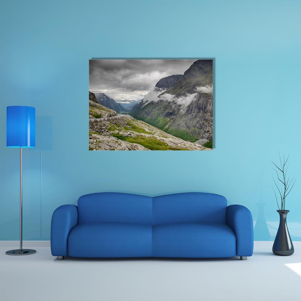 Winding Mountain Road Through Fog Canvas Wall Art in white, gray and green, single panel hung on a wall