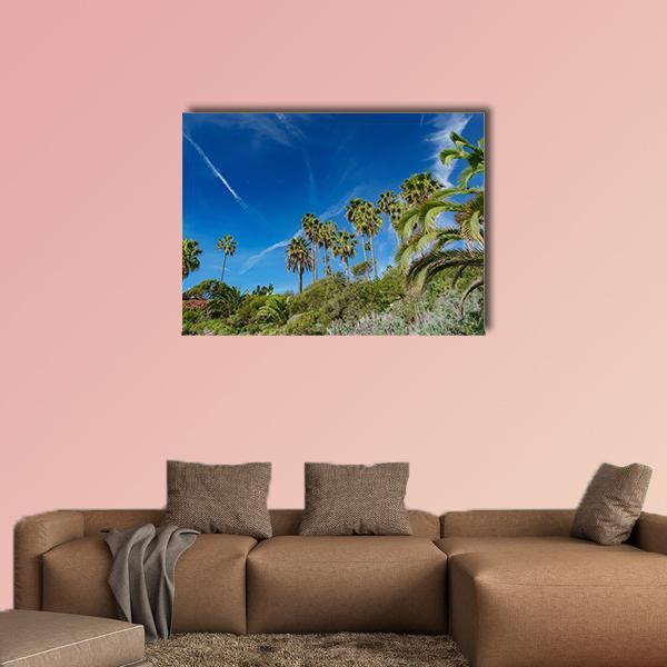 Sunny Coastal Palm Trees and Hills Canvas Wall Art in green and blue, single panel hung on a wall