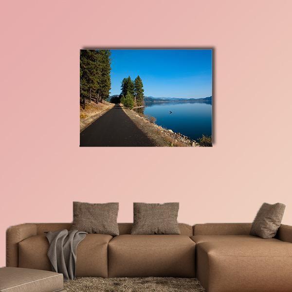 Calm Blue Lake with Lone Duck Canvas Wall Art in brown, green and blue, single panel hung on a wall