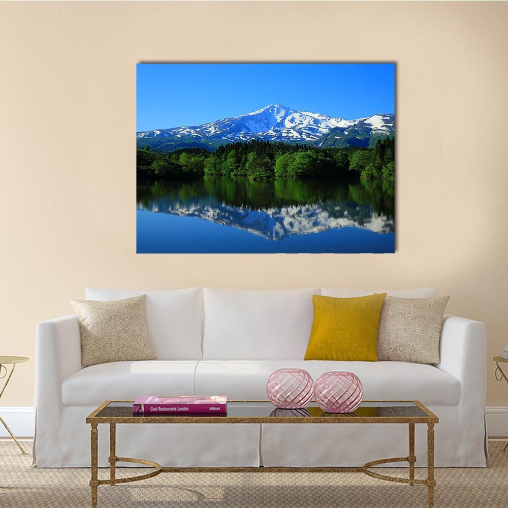 Green Mountain Reflected in Calm Lake Canvas Wall Art in white, green and blue, single panel hung on a wall
