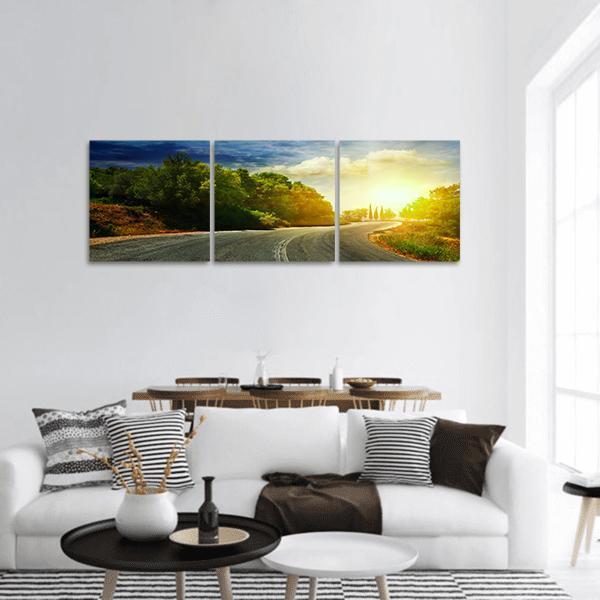 Winding Mountain Road at Sunset Panoramic Canvas Wall Art in yellow, green and blue, hung on a wall
