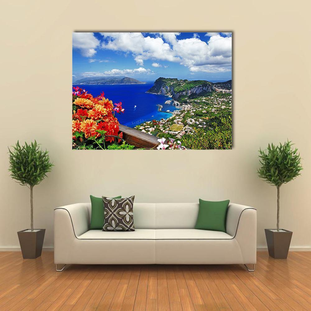 Capri Coastal Cliffs with Orange Dahlias Canvas Wall Art in orange, green and blue, single panel hung on a wall