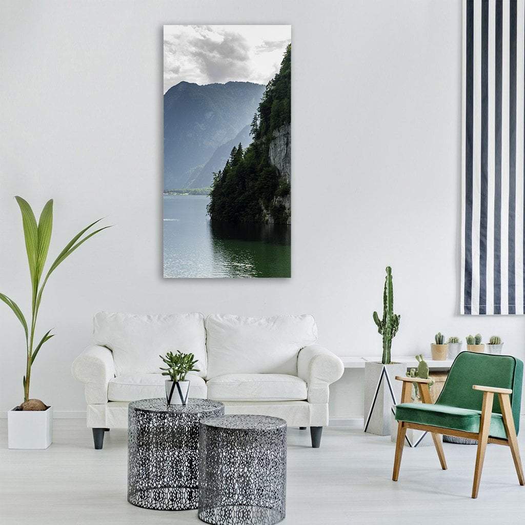 Steep Forest Cliff Over Green Lake Vertical Canvas Wall Art in gray, green and blue, single vertical panel hung on a wall