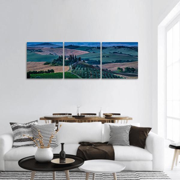 Tuscany Rolling Hills at Blue Hour Panoramic Canvas Wall Art in brown, green and blue, hung on a wall