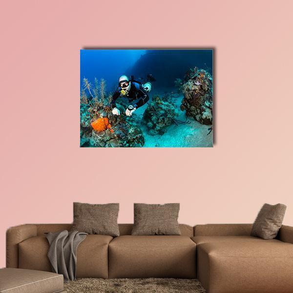 Scuba Diver on Tropical Coral Reef Canvas Wall Art in black and blue, single panel hung on a wall