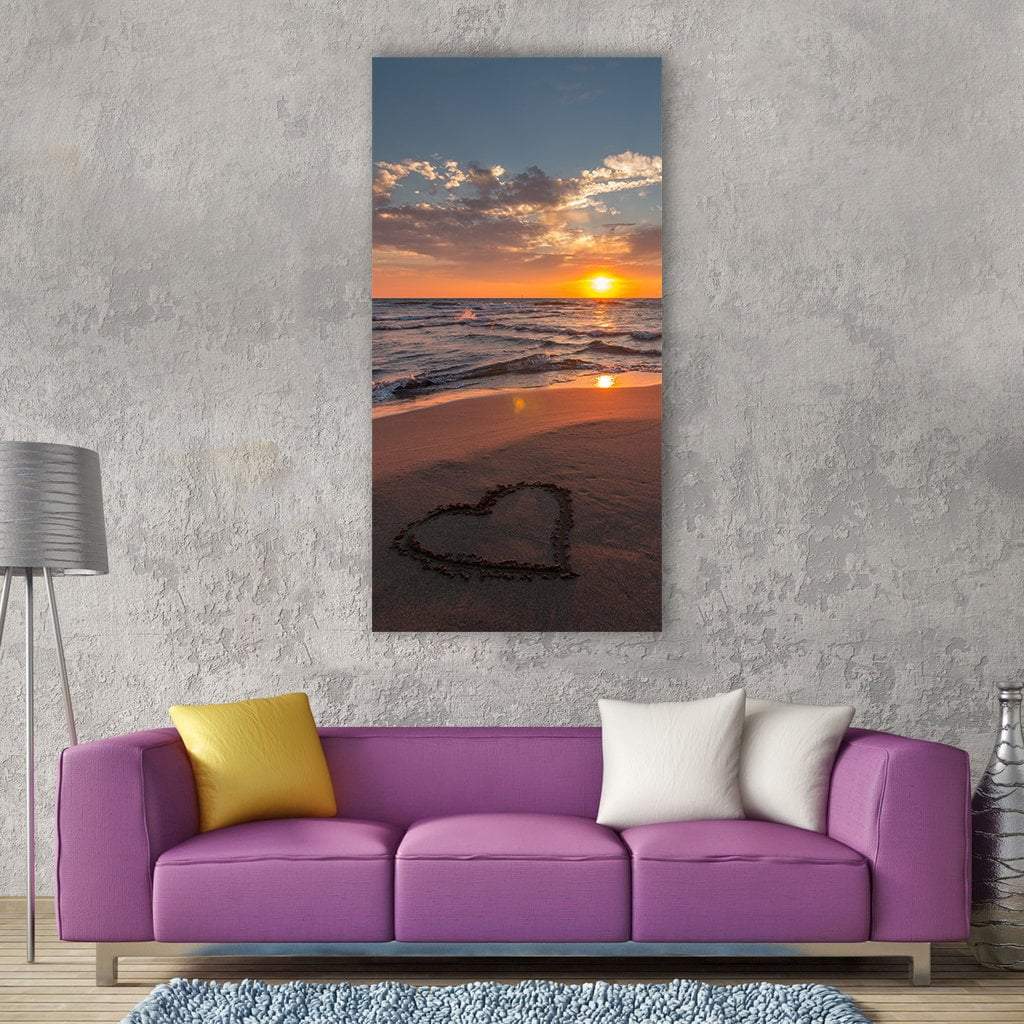 Heart Drawn in Sand on Sunset Beach Vertical Canvas Wall Art in brown, orange and blue, single vertical panel hung on a wall