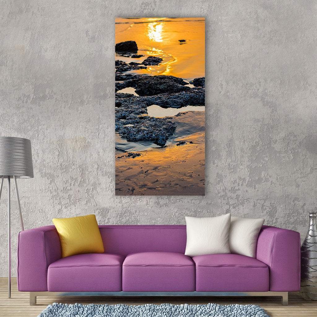 Sunset Beach with Wet Rocks Vertical Canvas Wall Art in black, orange and yellow, single vertical panel hung on a wall