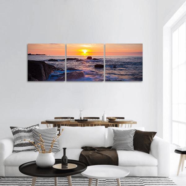 Sea Coast at Sunset Panoramic Canvas Wall Art in orange, yellow and blue, hung on a wall