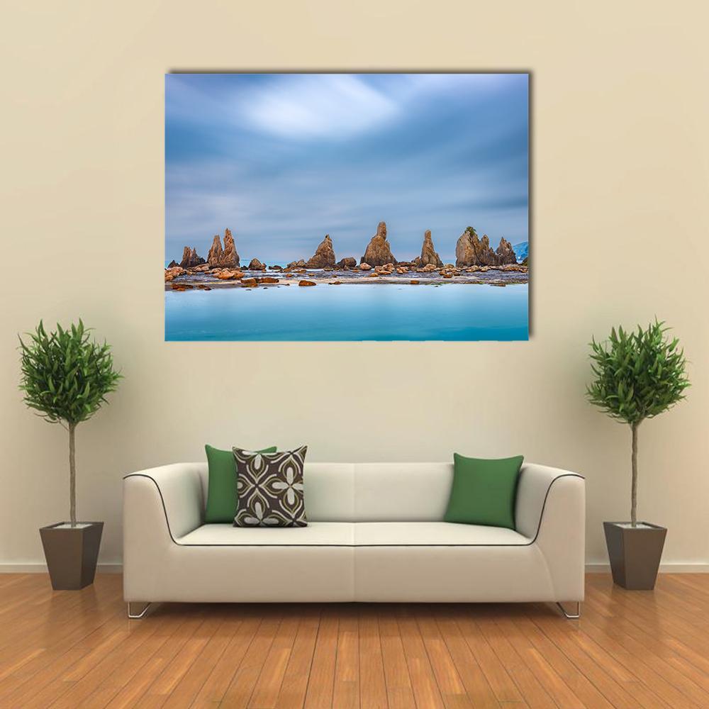 Coastal Rock Formations with Calm Sea Canvas Wall Art in beige, brown and blue, single panel hung on a wall