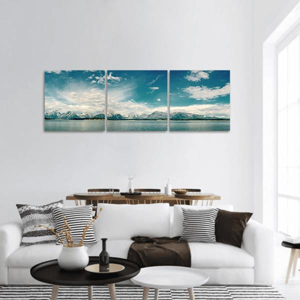 Sea Coastline Under Blue Sky Panoramic Canvas Wall Art in white and blue, hung on a wall