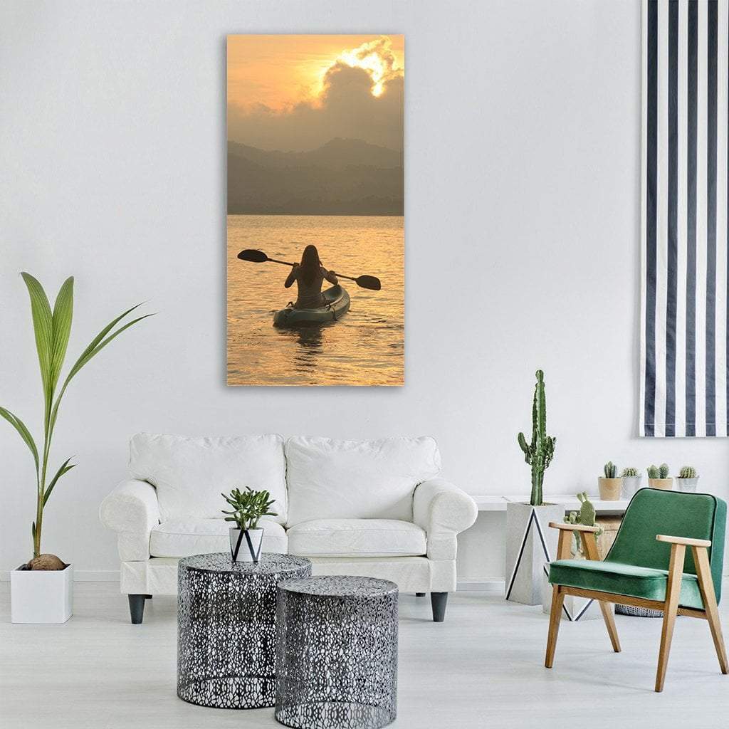 Kayaker at Sunrise Vertical Canvas Wall Art in gray, orange and yellow, single vertical panel hung on a wall