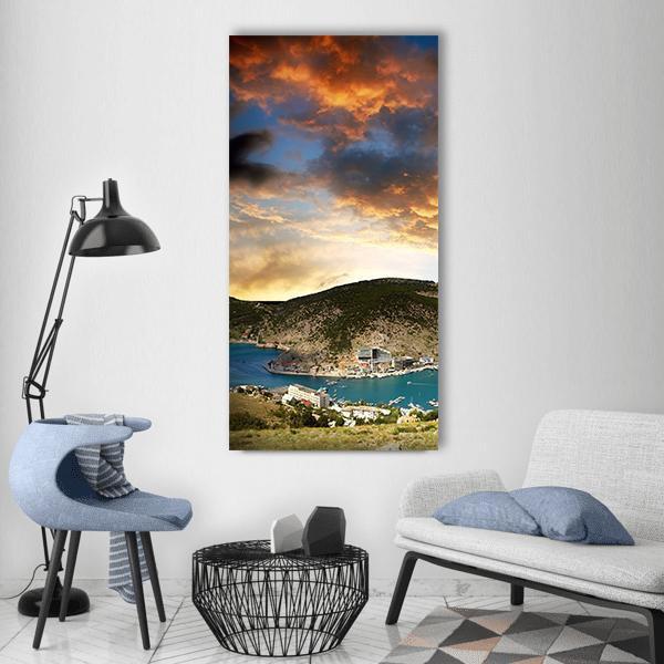 Coastal Bay at Sunset Vertical Canvas Wall Art in brown, orange and blue, single vertical panel hung on a wall