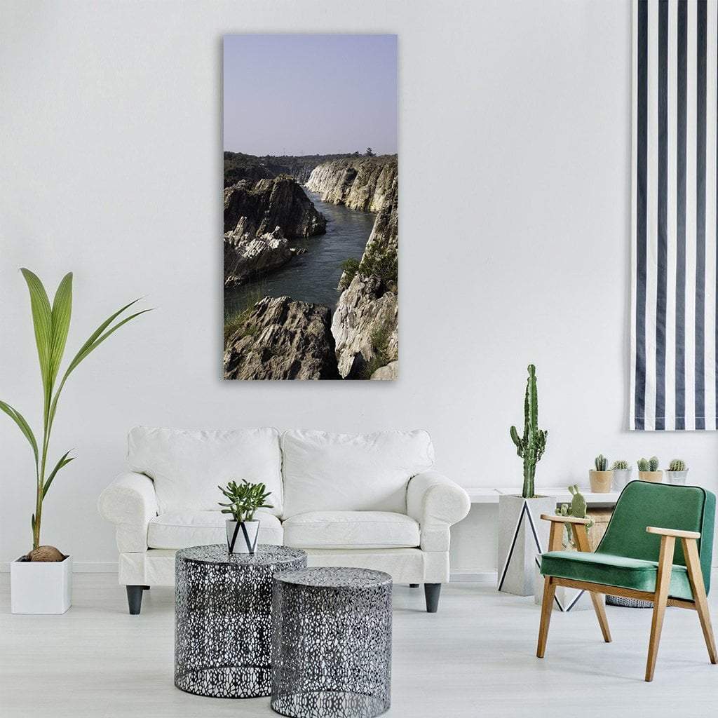 Seashore Rock Landscape Vertical Canvas Wall Art in gray, brown and blue, single vertical panel hung on a wall