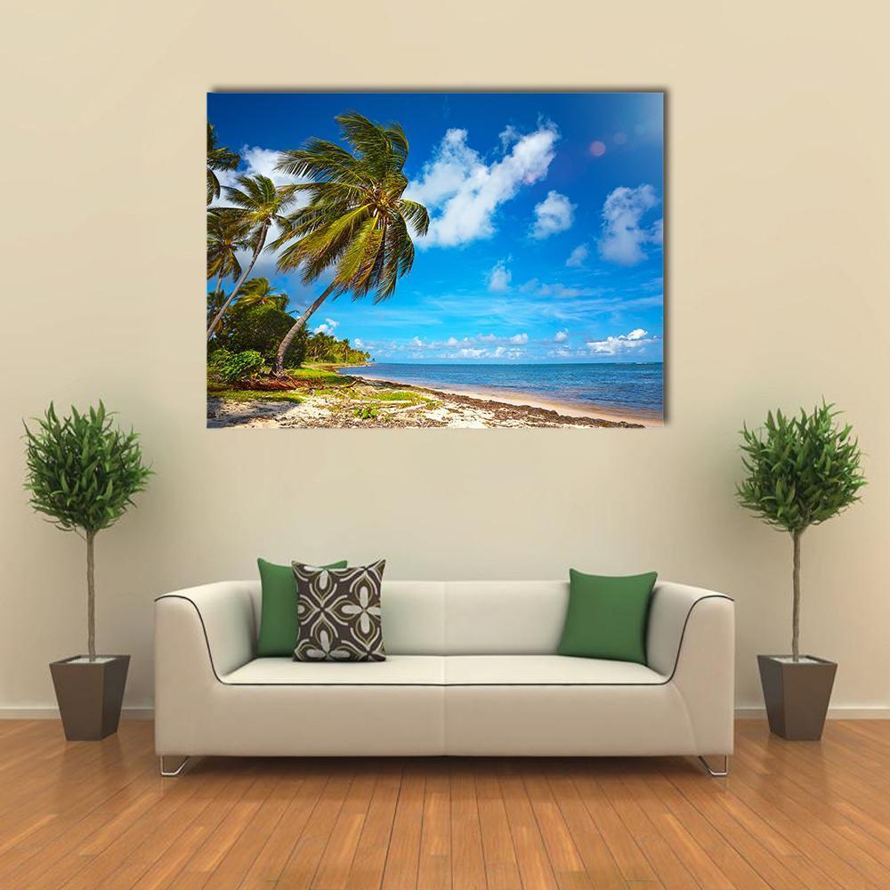Tropical Beach View Under Blue Sky Canvas Wall Art in beige, green and blue, single panel hung on a wall