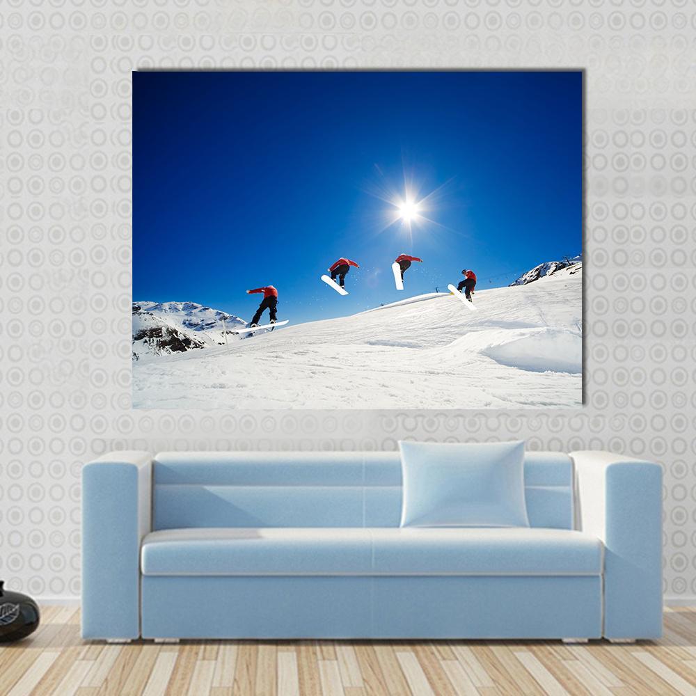 Snowboarder Sequence Over Jump Canvas Wall Art in white and blue, single panel hung on a wall