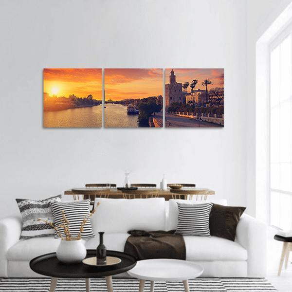 Seville Skyline at Sunset Panoramic Canvas Wall Art in orange, yellow and blue, hung on a wall