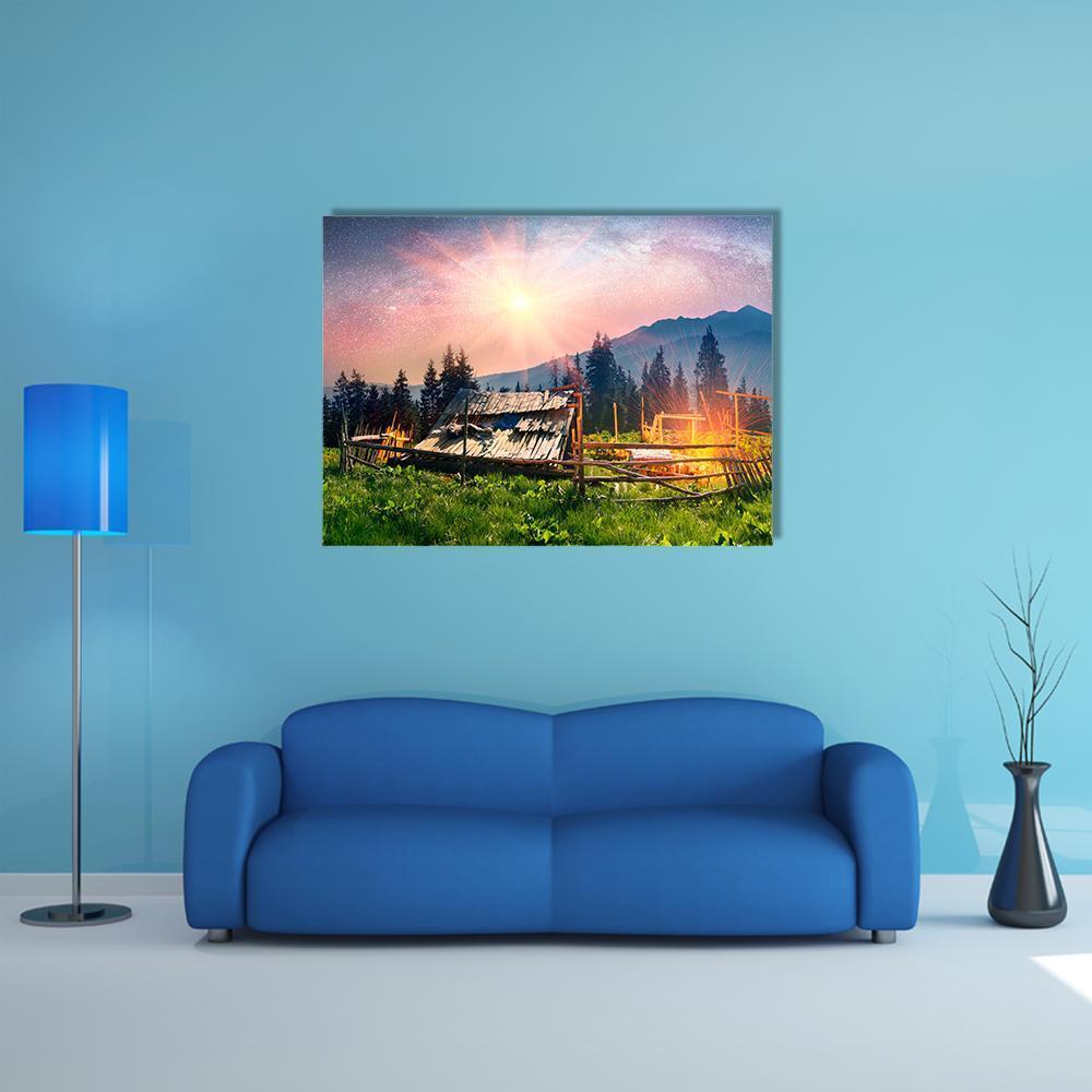 Mountain Cabin with Sheep Canvas Wall Art in green, purple and pink, single panel hung on a wall