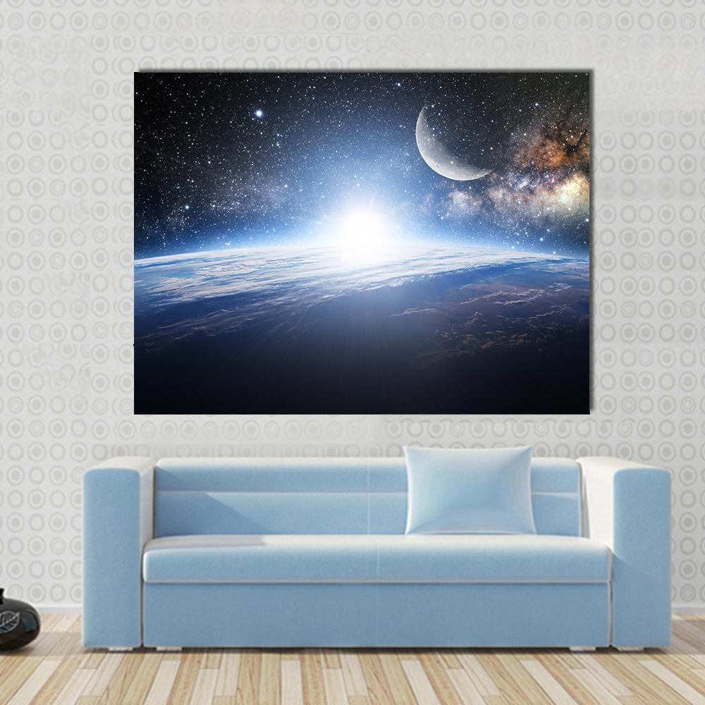 Sunrise Over Earth with Moon and Galaxy Canvas Wall Art in black, white and blue, single panel hung on a wall