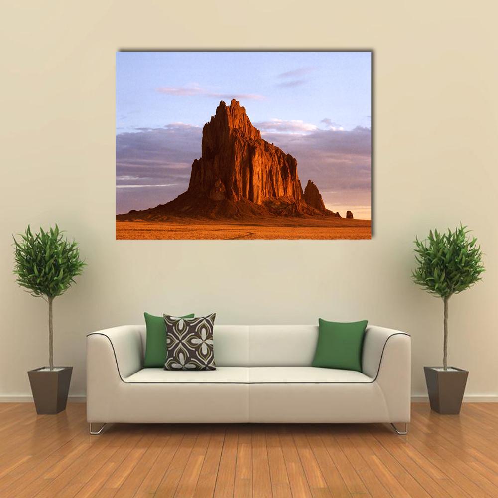 Shiprock Monolith at Golden Hour Canvas Wall Art in brown, orange and blue, single panel hung on a wall