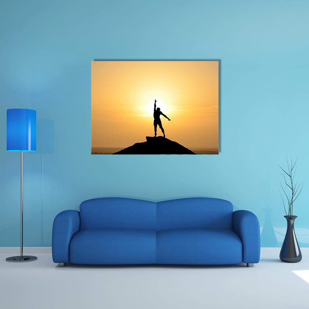 Businessman Silhouette with Raised Arms at Sunset Canvas Wall Art in black, orange and yellow, single panel hung on a wall